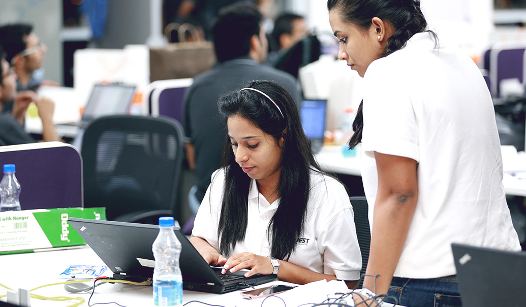 Two women working on computer together